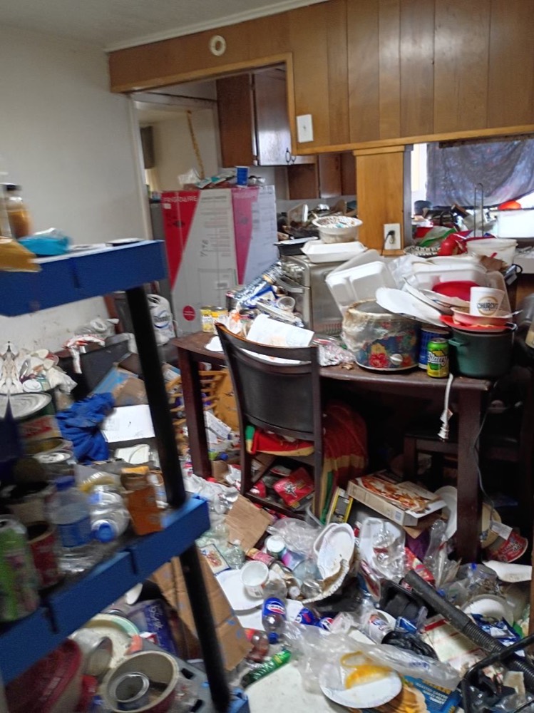 Room full of furniture and debris before removal